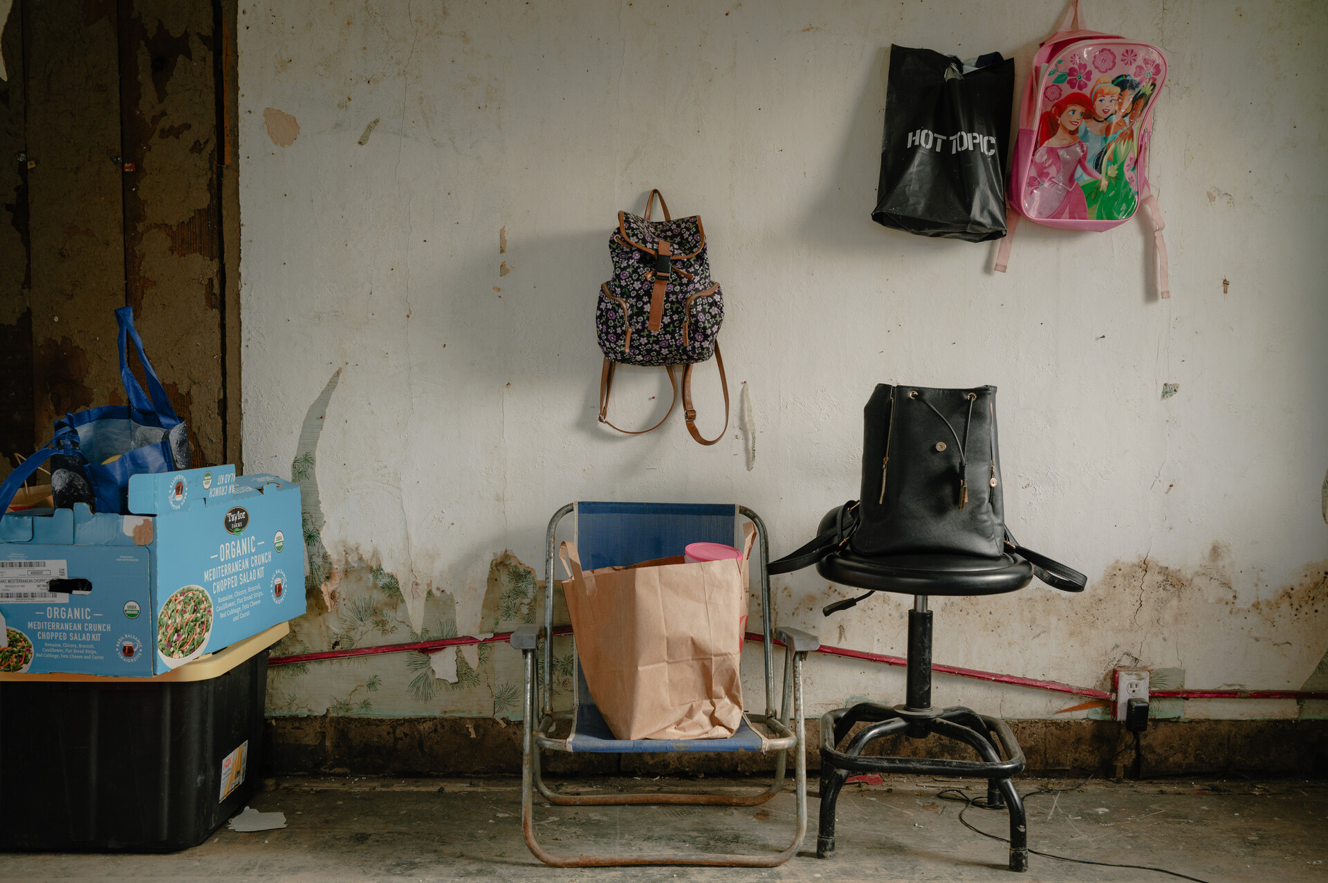 A brightly-colored backpack hangs from a white wall. 