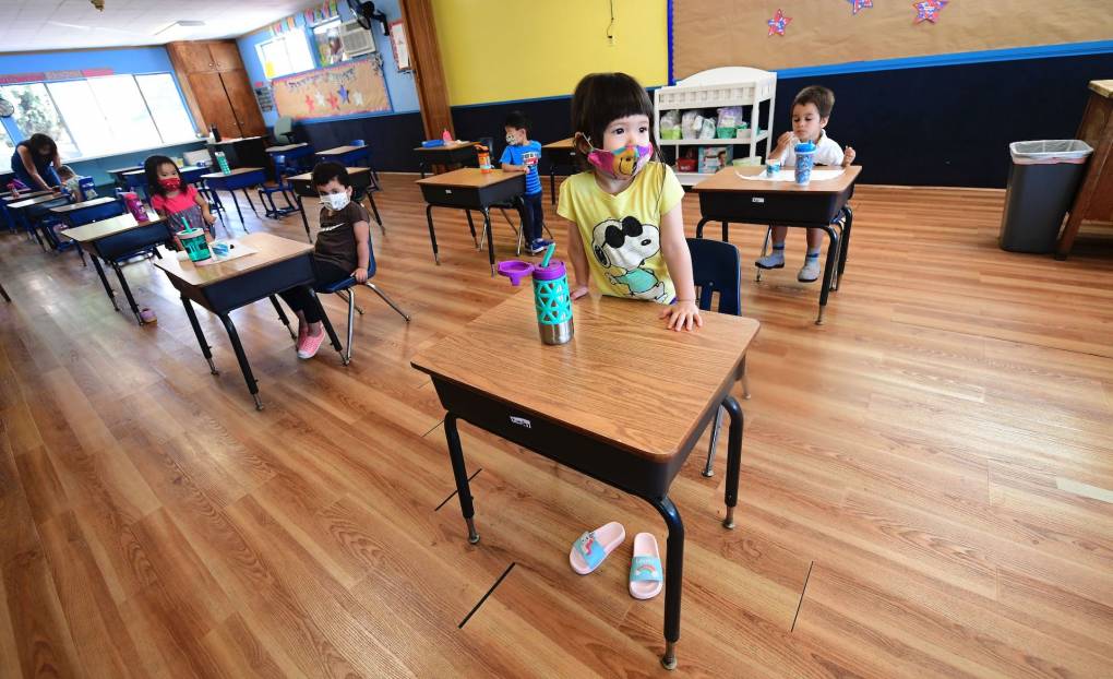 Children in a preschool class wear masks and sit at desks spaced apart as per coronavirus guidelines during summer school sessions in Monterey Park, California, on July 9, 2020. Frederic J. Brown/AFP via Getty Images