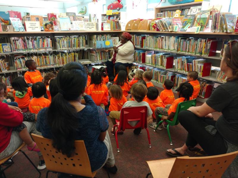 Children's librarian Mahasin Abuwi Aleem reads to children during story time at Oakland's Main Library.