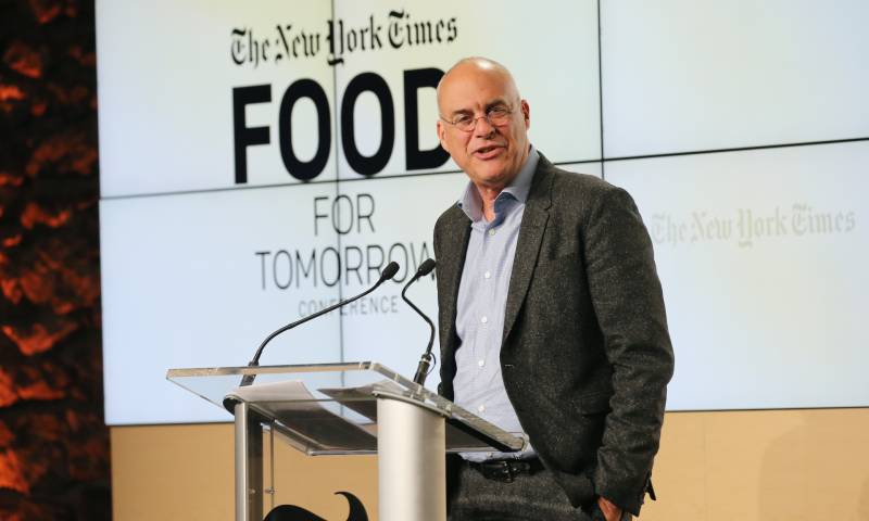 Mark Bittman stands at the podium addressing the audience at the New York Times Food for Tomorrow Conference