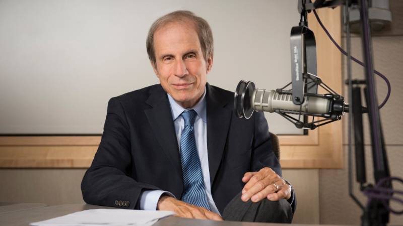 Michael Krasny sits in front of a microphone.