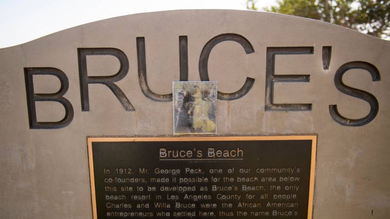 A photo of Charles and Willa Bruce stands above a plaque that tells the history of Bruce's Beach