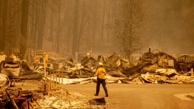 A firefighter surveys a destroyed downtown during the Dixie fire in Greenville, California on Aug. 5, 2021.