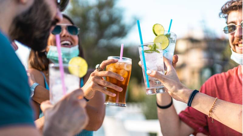 a group of young adults toast drinks outdoors
