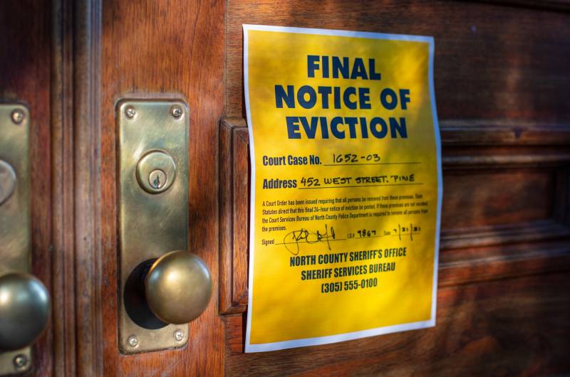 Yellow final notice of eviction on wood door