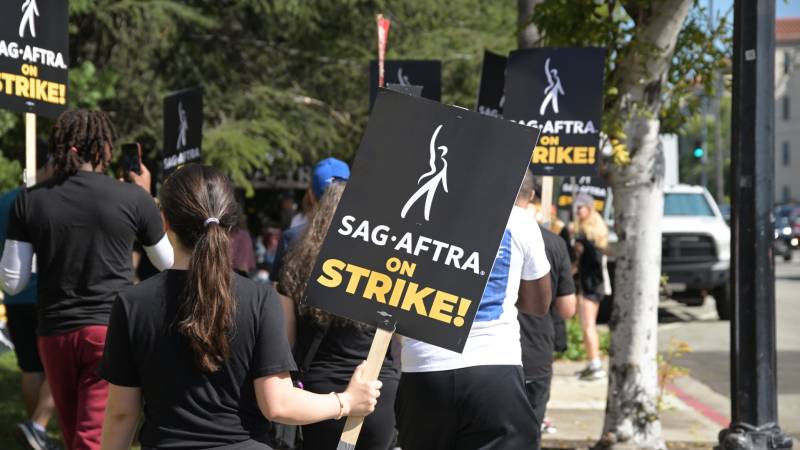 SAG-AFTRA picketers holding signs while on strike.