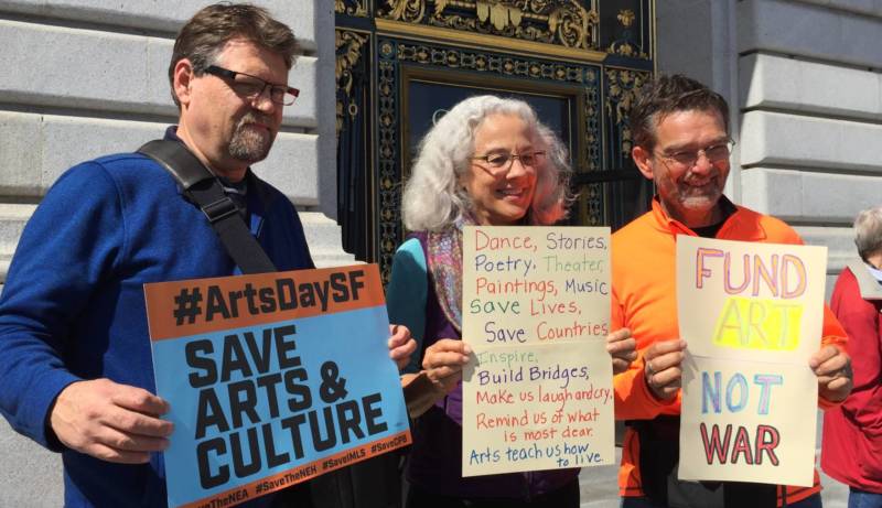 Signs at the rally for arts funding Wednesday at San Francisco City Hall