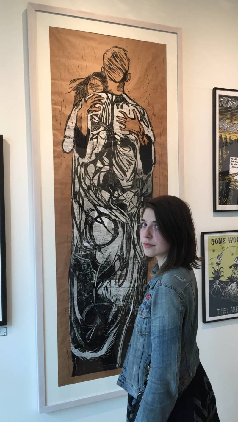 Kate Lasker standing in front of her relief print "Newsfeed" part of the show ‘Creation and Resistance