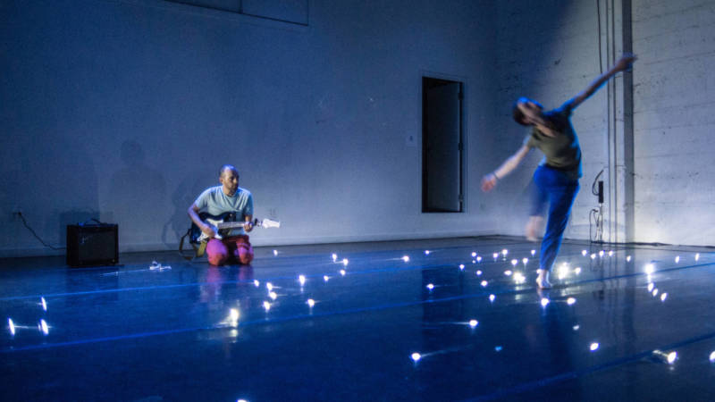 Adam Smith plays the guitar while Arletta Anderson dances through the universe in 'weather//body' at CounterPulse.