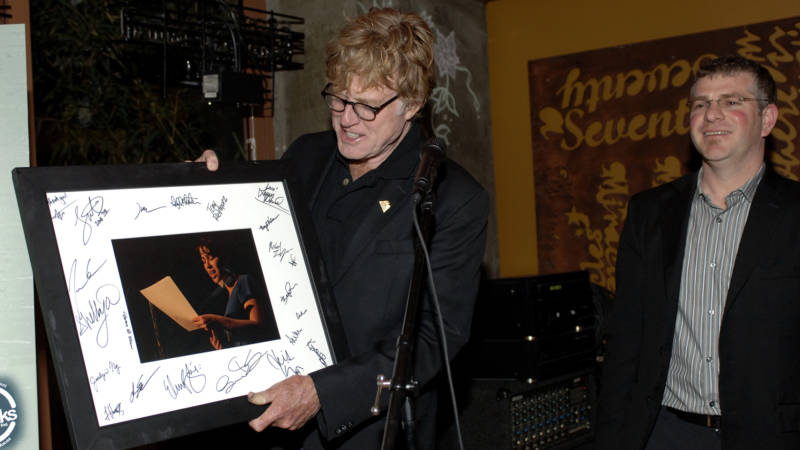 Robert Redford (L) is presented a signed picture from the the Youth Speaks Foundation and James Kass (R) at the Private Reception for the Premiere of HBO's Brave New Voices & Youth Speaks back in 2009 