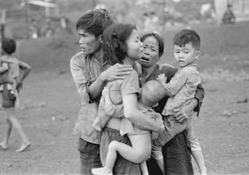Civilians huddle together after an attack by South Vietnamese forces. Dong Xoai, June 1965.