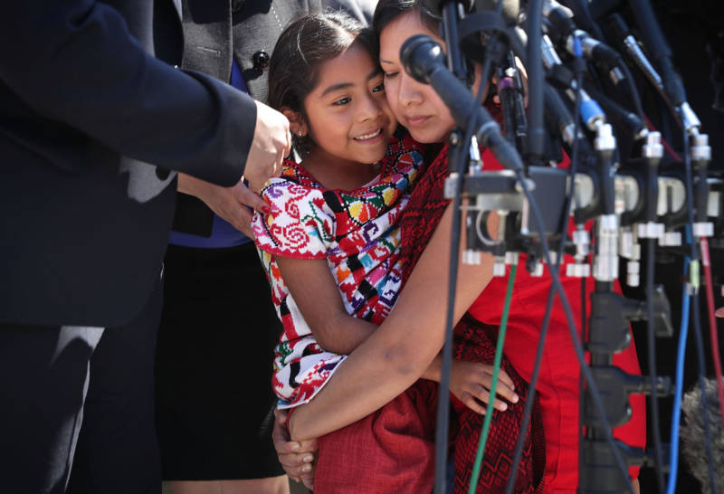 Six-year-old Sophie Cruz (L) of Los Angeles is held by her mother Zoyla Cruz (R) after she spoke to members of the media in front of the U.S. Supreme Court April 18, 2016 in Washington, D.C.
