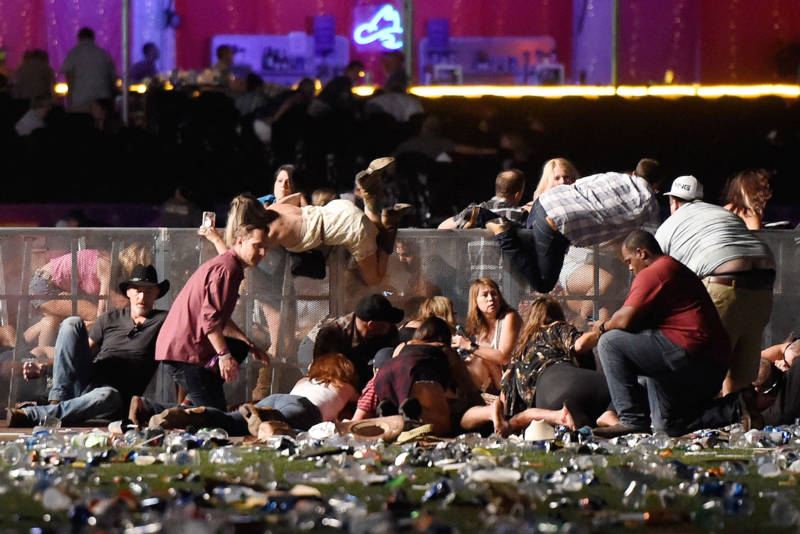 People scramble for shelter at the Route 91 Harvest country music festival in Las Vegas after a gunman opened fire, leaving 59 people dead and more than 500 injured, on Oct. 1, 2017.