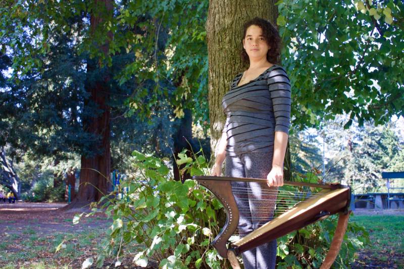 María José Montijo stands among the trees in the park near her home in Oakland.