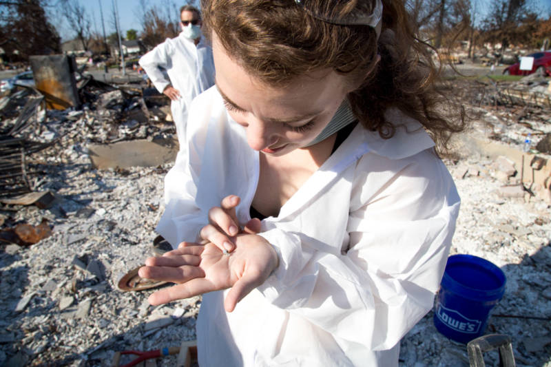Laura Sudduth finds a pair of dimond earings she recived in the eight grade amost the remains of her childhood home in Coffey Park