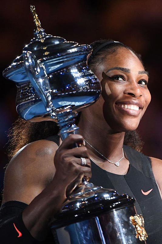 Serena Williams of the US celebrates with the championship trophy during the awards ceremony after her victory against Venus Williams of the US in the women's singles final on day 13 of the Australian Open tennis tournament in Melbourne on January 28, 2017. 