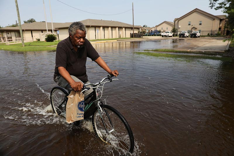 A man returns from the grocery store through high water along a street in Orange as Texas slowly moves toward recovery from the devastation of Hurricane Harvey on September 6, 2017 in Orange, Texas. 