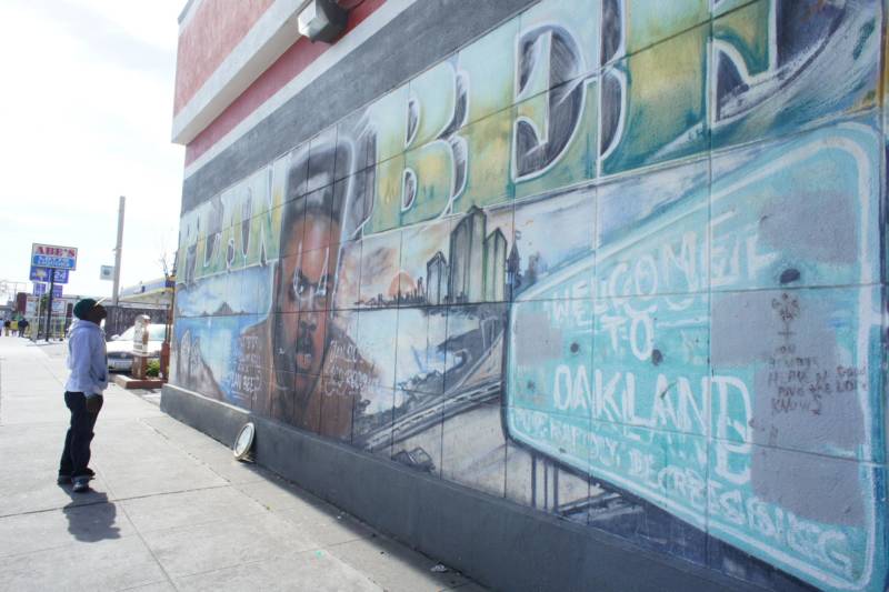 Rapper Ian Kelly takes a long look at one of the longest standing murals in Oakland, the image of slain East Oakland rapper Plan Bee.