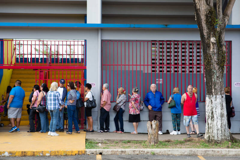 Residents of Aguada, Puerto Rico, stand in line for food aid at a FEMA distribution center on February 7, 2018. Local officials, including police, distribute supplies provided by FEMA once a week.