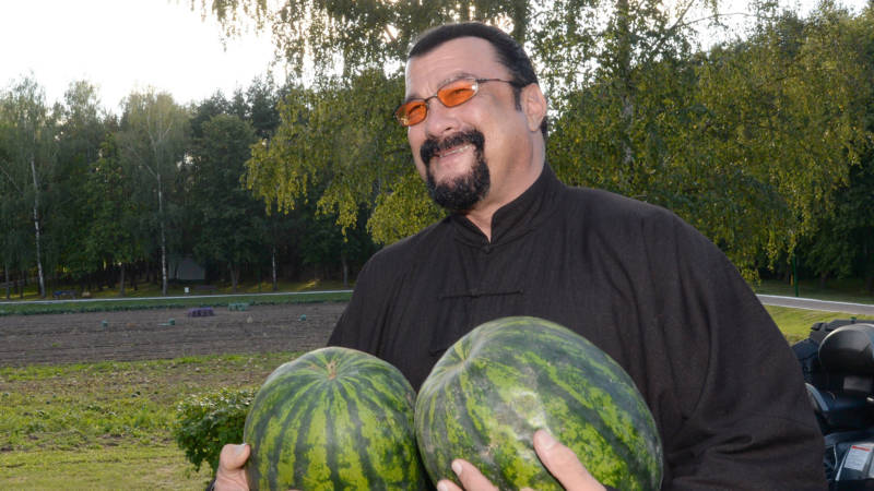 Steven Seagal holds two water melons during his meeting with the Belarus President at his residence of Drozdy, outside Minsk, on August 24, 2016. 