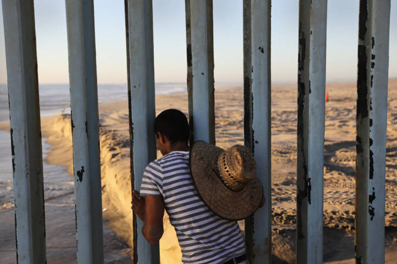 A man looks through the U.S.-Mexico border fence into the United States from Tijuana, Mexico, in 2016. Friendship Park on the border is one of the few places on the 2,000-mile border where separated families are allowed to meet.