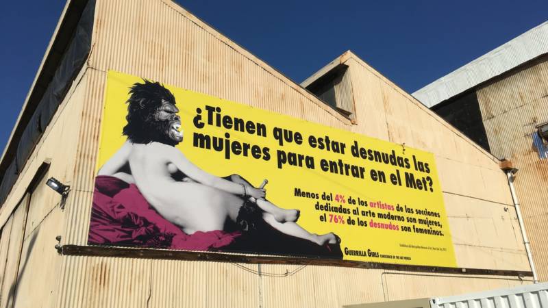 'Beyond the Streets' boasts one of the Guerrilla Girls' most well-known billboards — in Spanish. It translates to "Do women have to be naked to get into the Met? Less than 4 percent of the artists in the modern art sections are women, but 76 percent of the nudes are female."