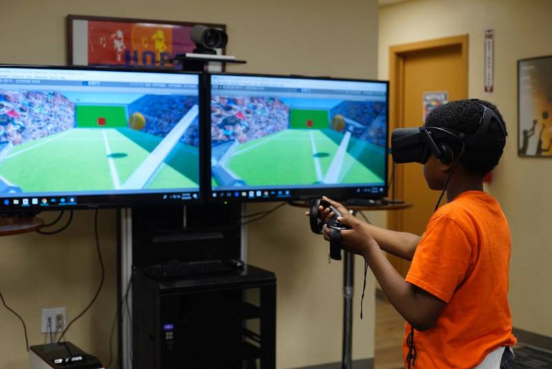 An attendee of the David E. Glover Center plays with a VR headset.