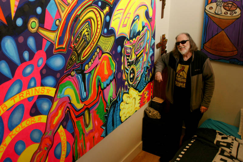 Robert Gill shows off his latest painting inside his East Oakland apartment.