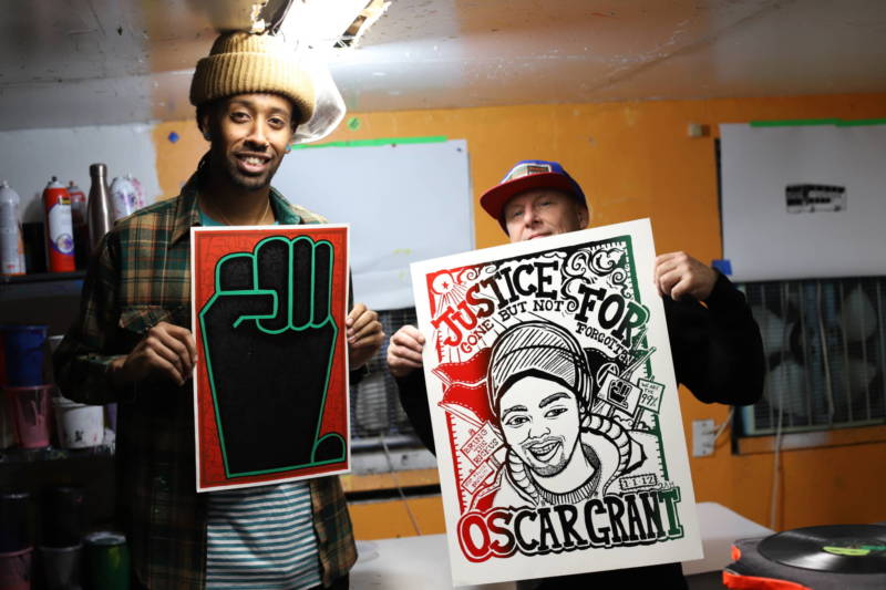 Kalleb Arefaine and Jon-Paul Bail printed thousands of anti-police brutality posters over the past decade. Bail (right) holds a poster he created with Aambr Newsom in 2012.