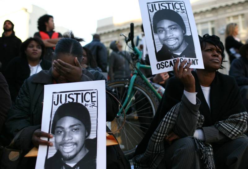 Protestors carry signs with a picture of slain 22-year-old Oscar Grant III during a demonstration at Oakland City Hall Jan. 14, 2009 in Oakland.