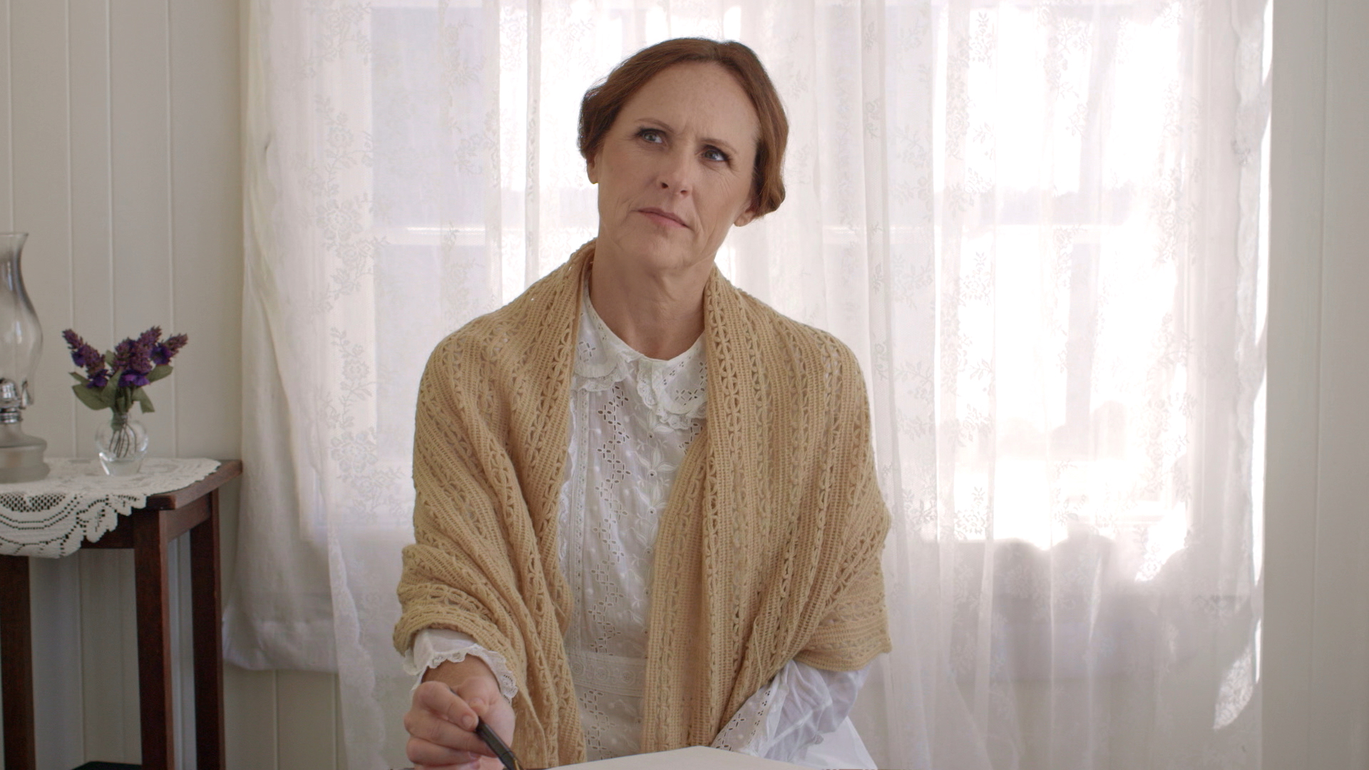 Emily (Molly Shannon) thinking at her desk in 'Wild Nights with Emily.'