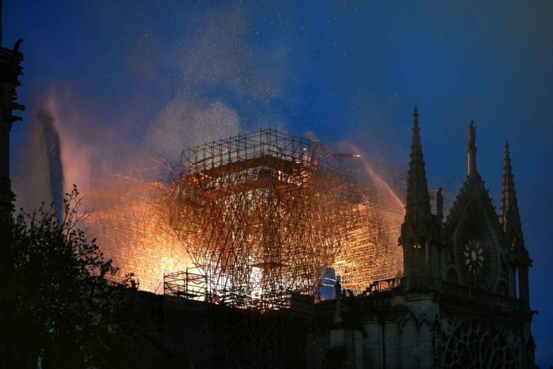 Flames are doused through the scaffolding erected on the roof of the Notre-Dame de Paris Cathedral after a fire broke out on April 15, 2019, in the French capital Paris. 