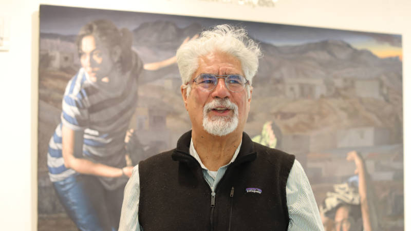 Curator David J. de la Torre stands in front of "La Guia (The Guide)" by Rigoberto Gonzalez in the Jewish Community Center of San Francisco. 
