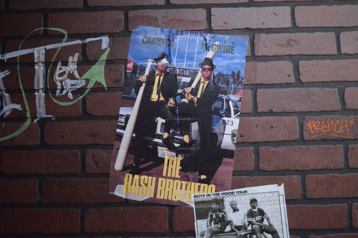 Posters and flyers on a faux-brick wall at "The 90's Experience."