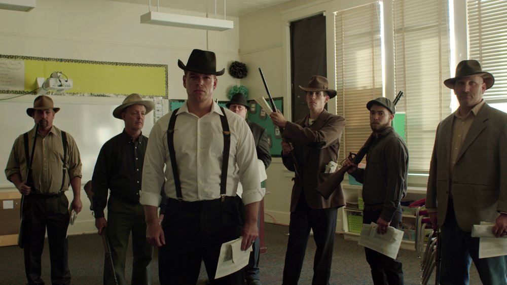 Town residents dressed in period costume stand in a modern day classroom in "Bisbee '17," as they re-enact the deputizing of a private police force that broke up a brewing strike at a copper mine on July 12, 1917.