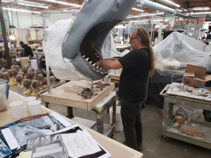 Greg Nicotero risks his safety to sculpt a new mouth for the museum-bound Bruce. Notice the army of zombie heads on the floor to Nicotero's left, awaiting use for an episode of 'The Walking Dead'.