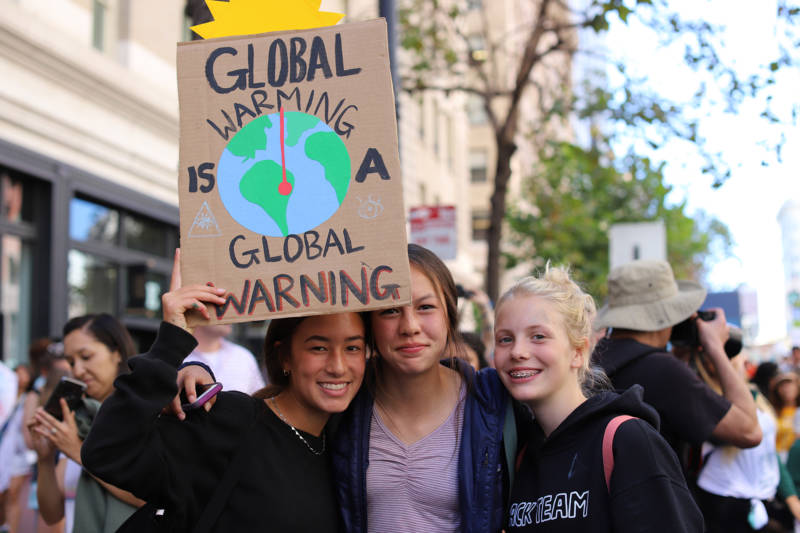 Demonstrators at the Climate Strike in San Francisco on Sept. 20, 2019. Three teenage girls hold a sign that says "Global warming is a global warning."