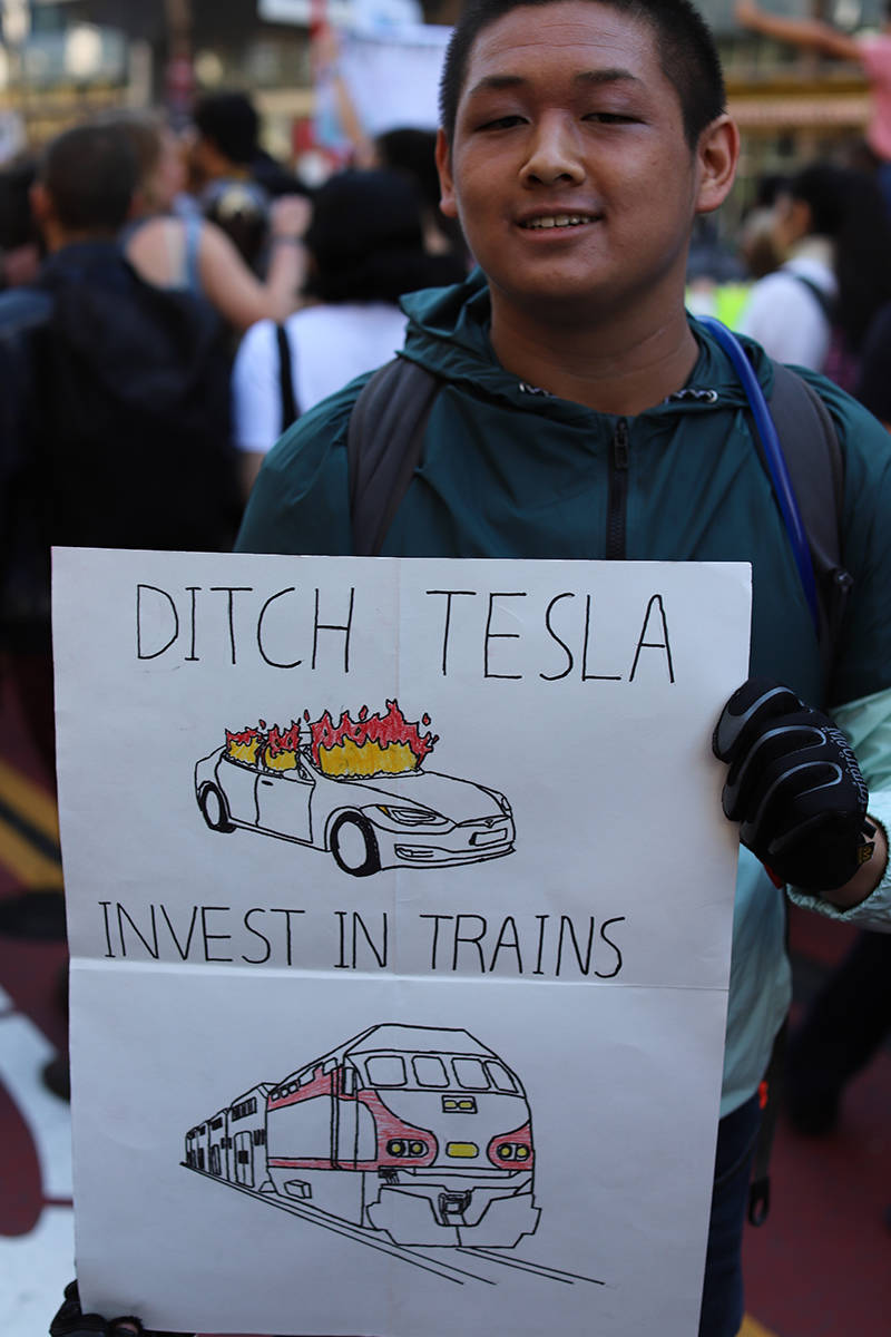 Demonstrators at the Climate Strike in San Francisco on Sept. 20, 2019. A young man holds a sign that says "Ditch Tesla, invest in trains."