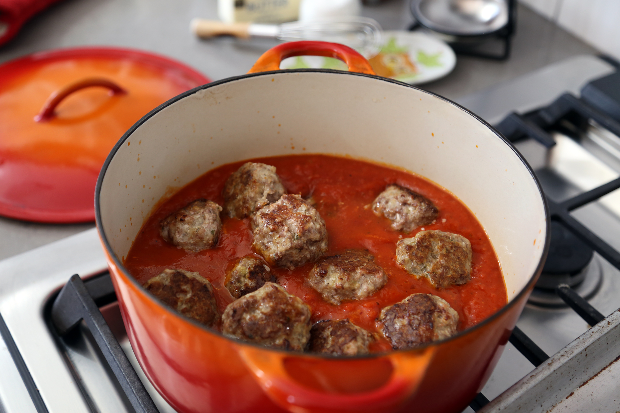 Meatballs simmering in tomato sauce.