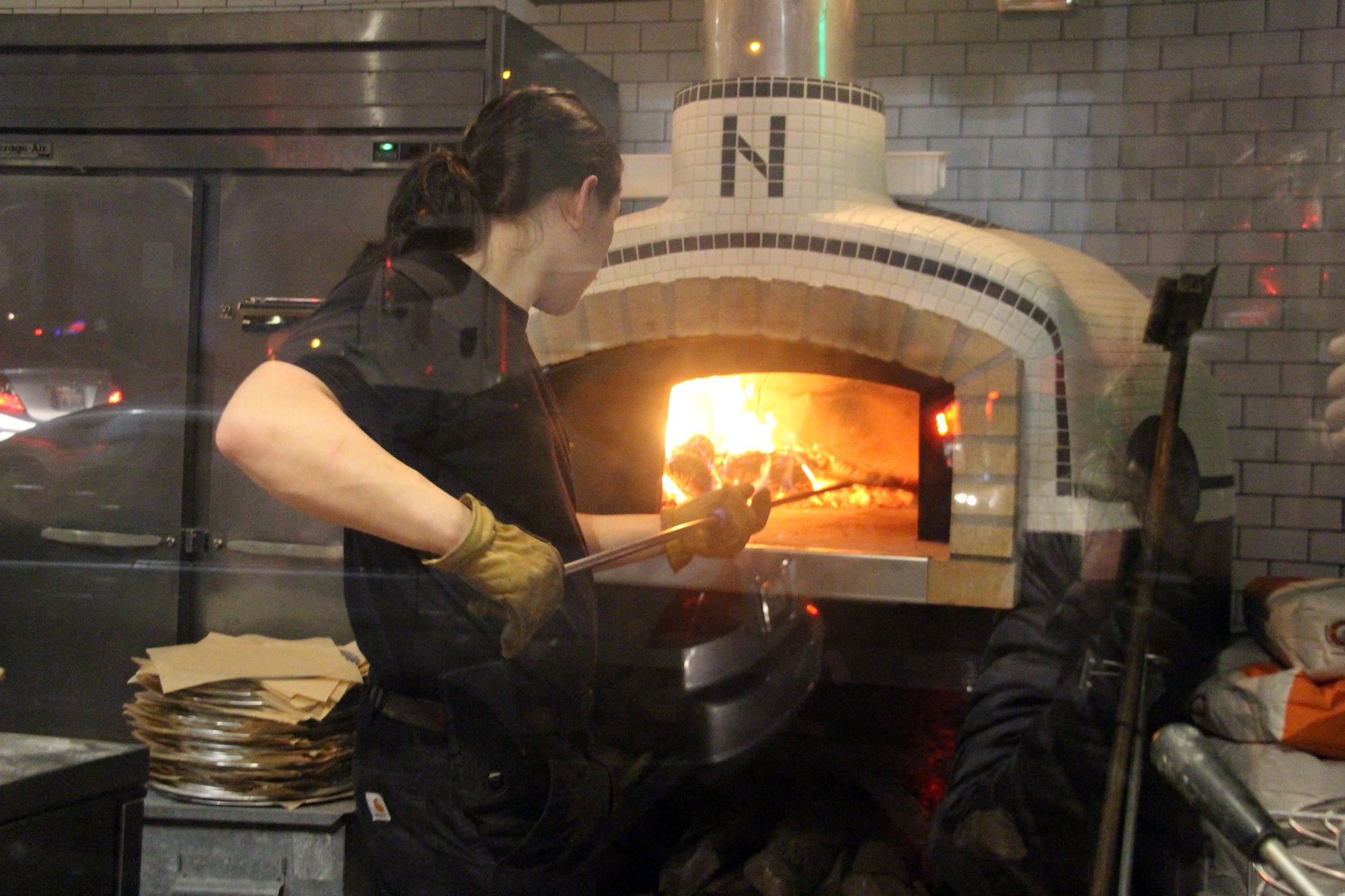 Justin Gee making pizza in the wood-fired oven at Bare Knuckle.