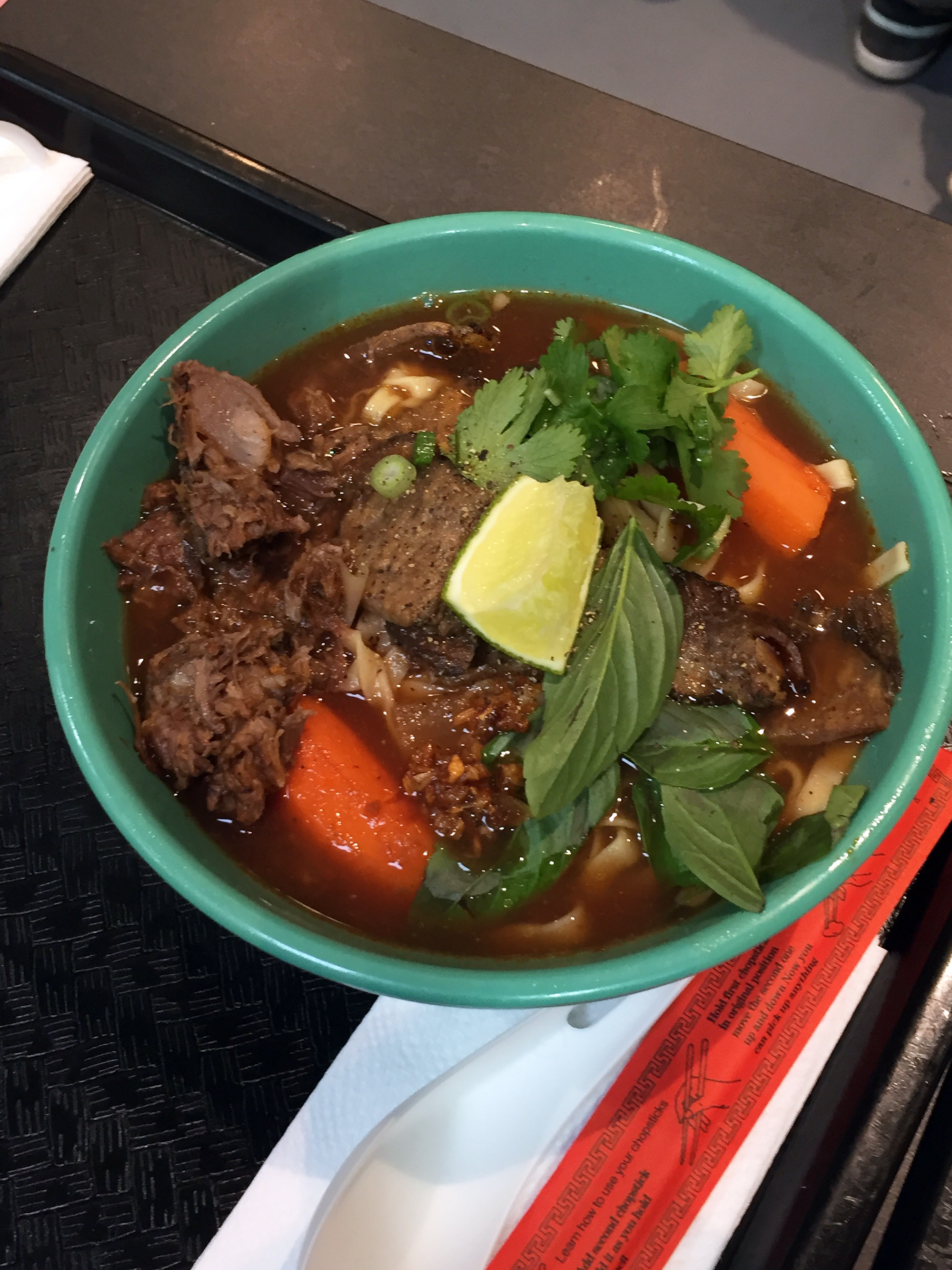 Koh-ko pairs hearty beef broth with egg noodles, braised beef, bok choy, crispy garlic, red onion, and cilantro.