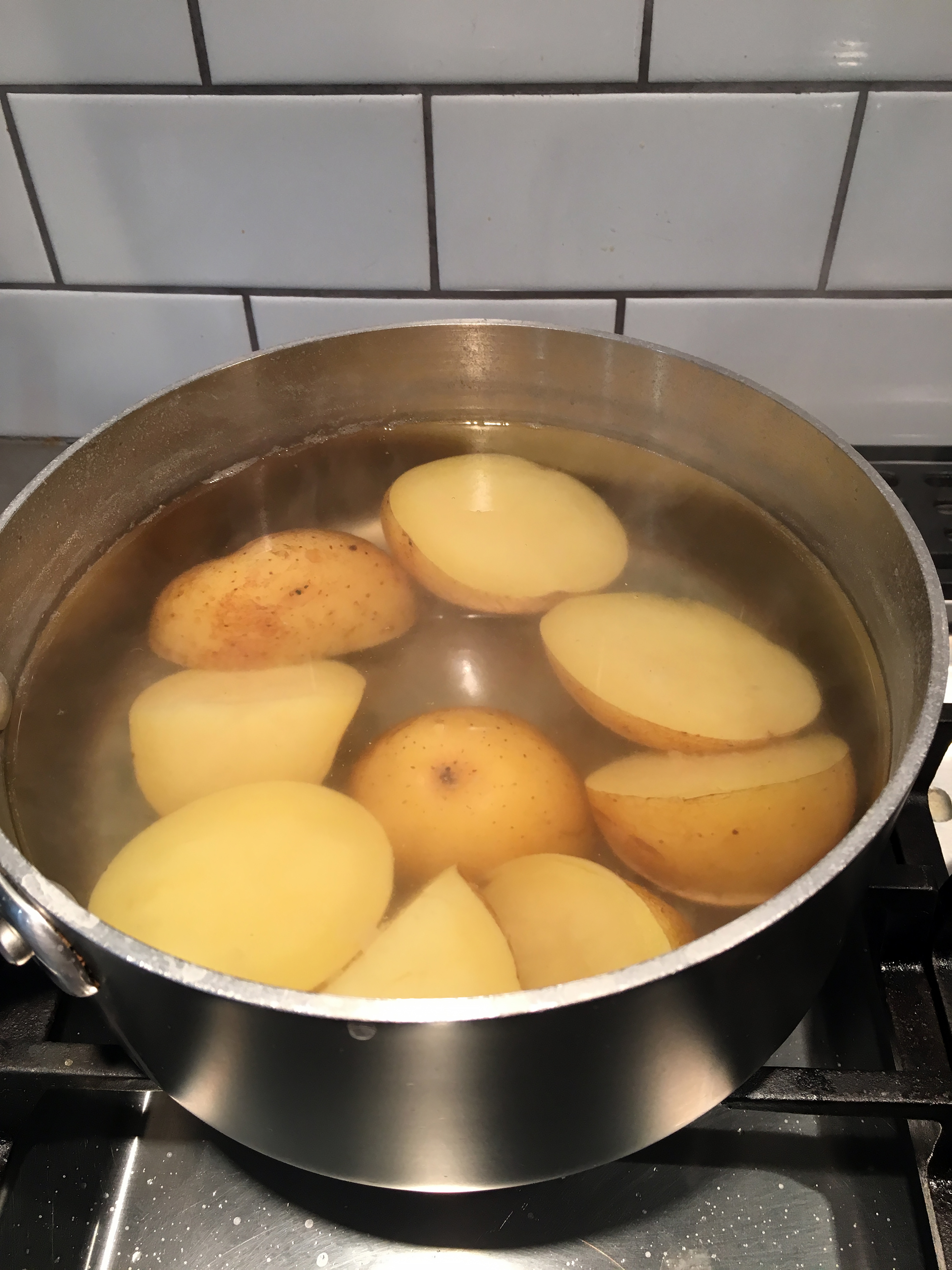 Put the potatoes in a saucepan with cold water to cover, add a few teaspoons kosher salt, then bring to a boil over medium-high heat. Reduce the heat to medium-low to maintain a simmer and cook until tender, about 20 minutes. 