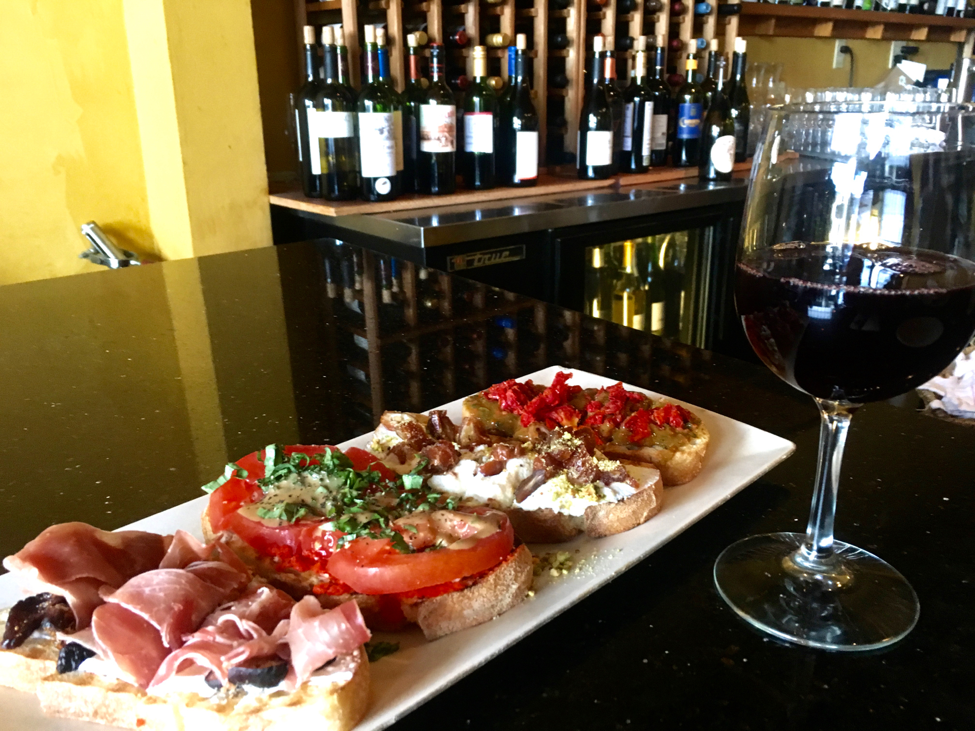 A glass of pinot noir and a selection of savory and sweet bruschetta at B Street & Vine.