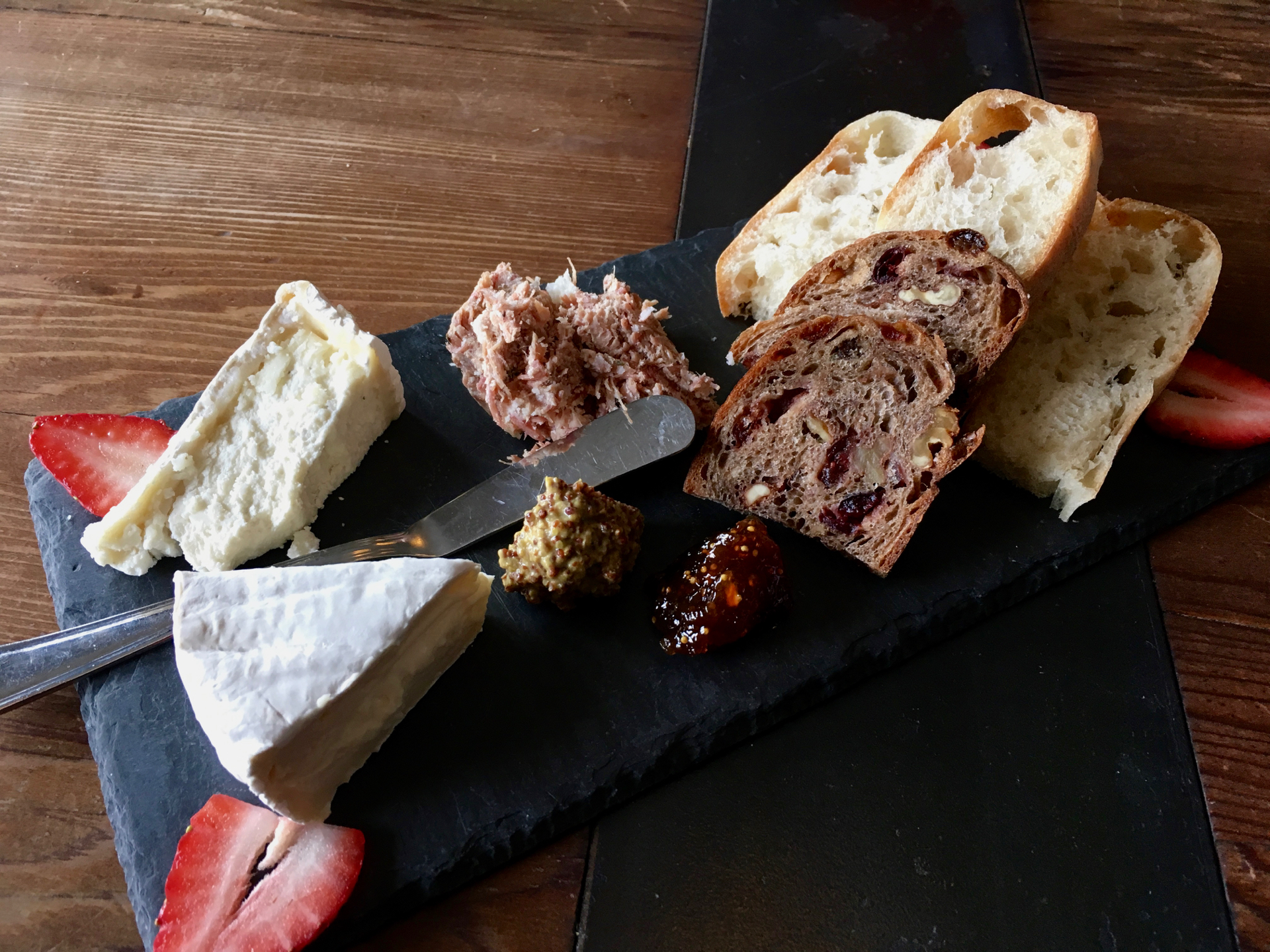 A cheeseboard at Rootstock Wine Bar with Marin French triple cream brie, Cypress Grove truffle tremor, pork rillette and Acme bread.