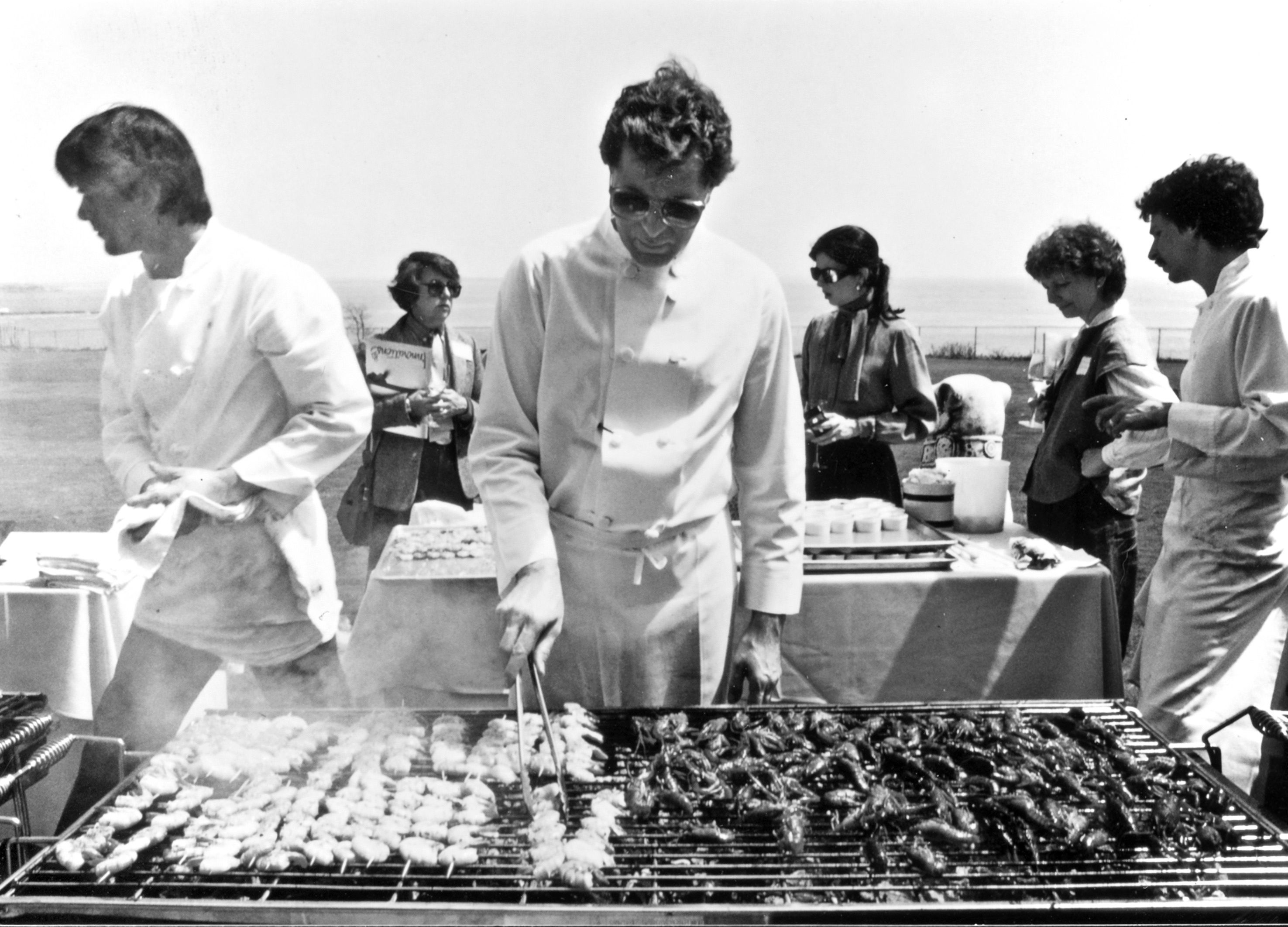 Jeremiah Tower grills lunch for 100 food journalists on the lawn of the Astor mansion in Newport Beach, R.I., in 1983. Tower wowed the East Coasters with his "new California" or new American cooking.