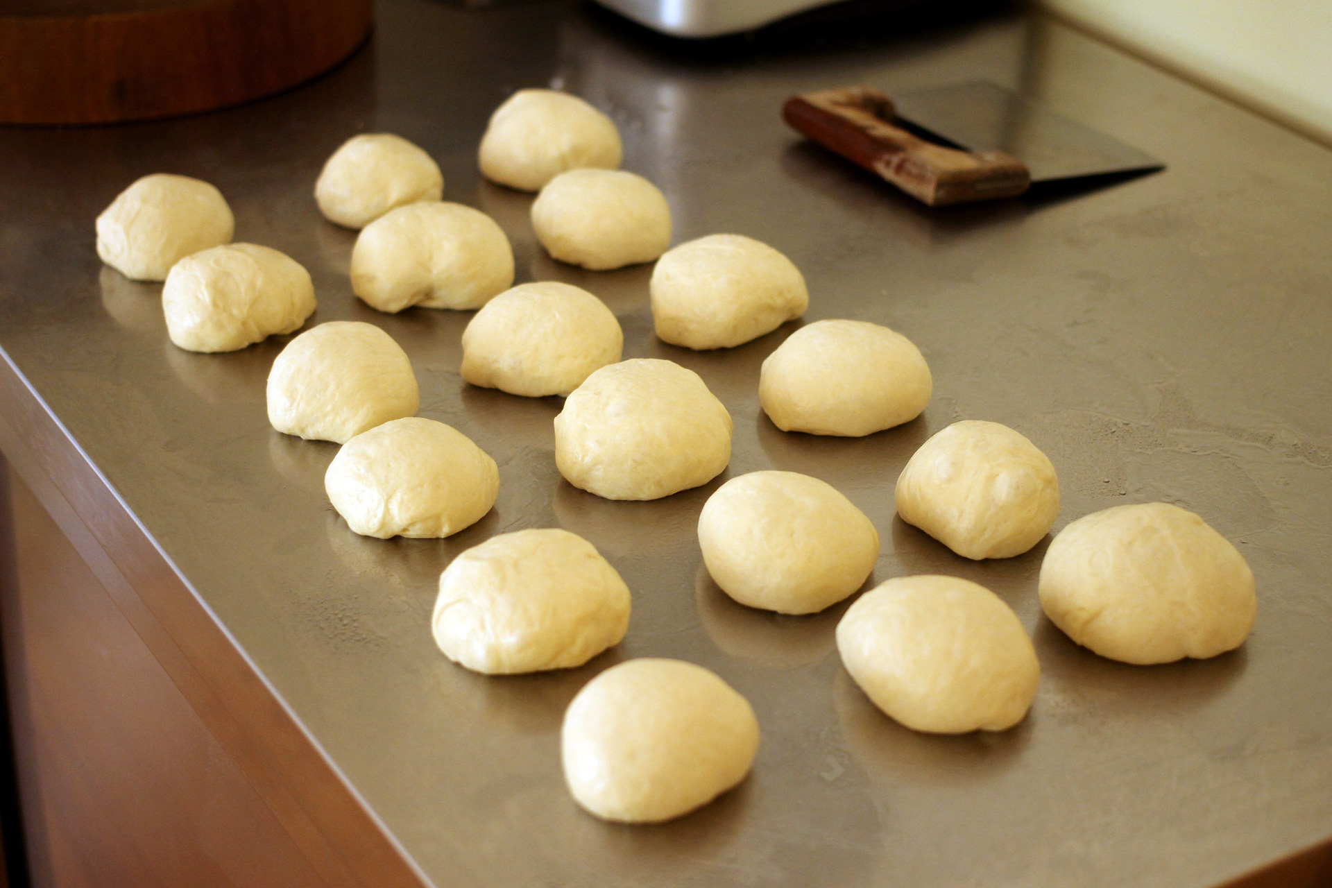 Shape the dough into balls before rolling it into hot dog bun-shaped cylinders.