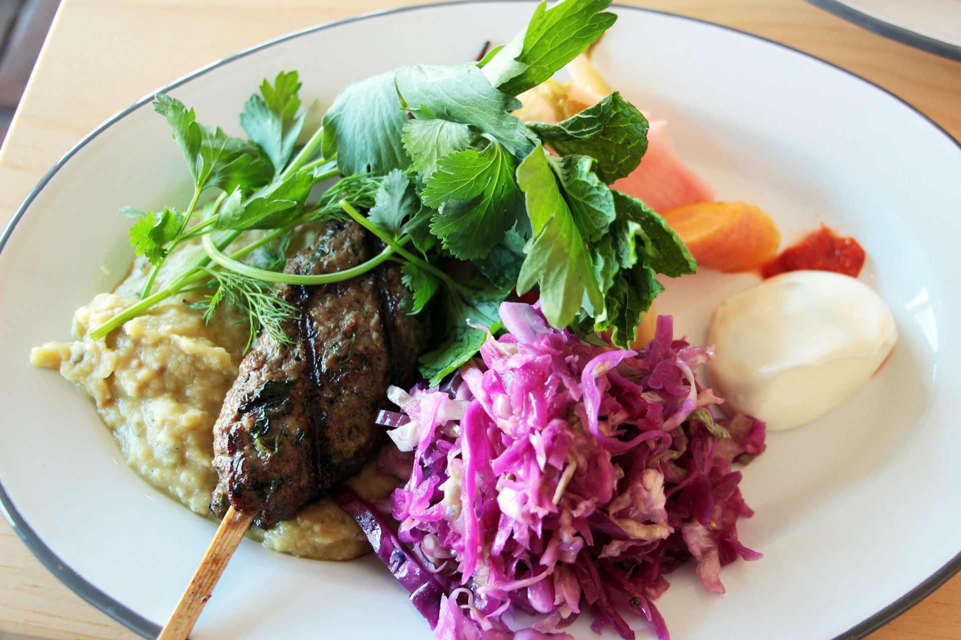 Lamb Kebab Plate with served with homemade purple-cabbage sauerkraut, mashed red lentils, and pickles of fennel, carrot and celery.