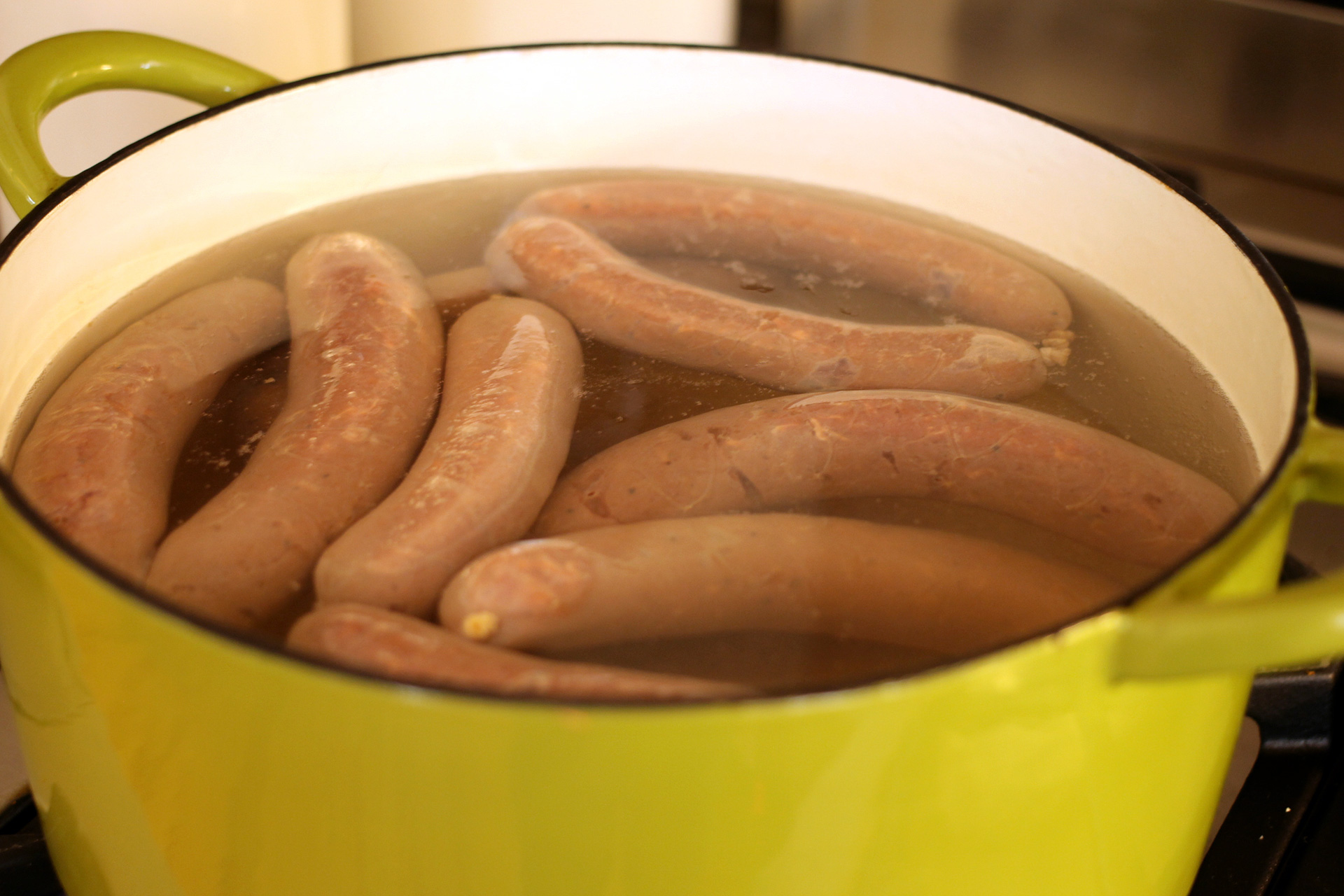 Cooking the sausages gently in water will keep the skins from getting wrinkled when you finish them on the grill or stovetop.