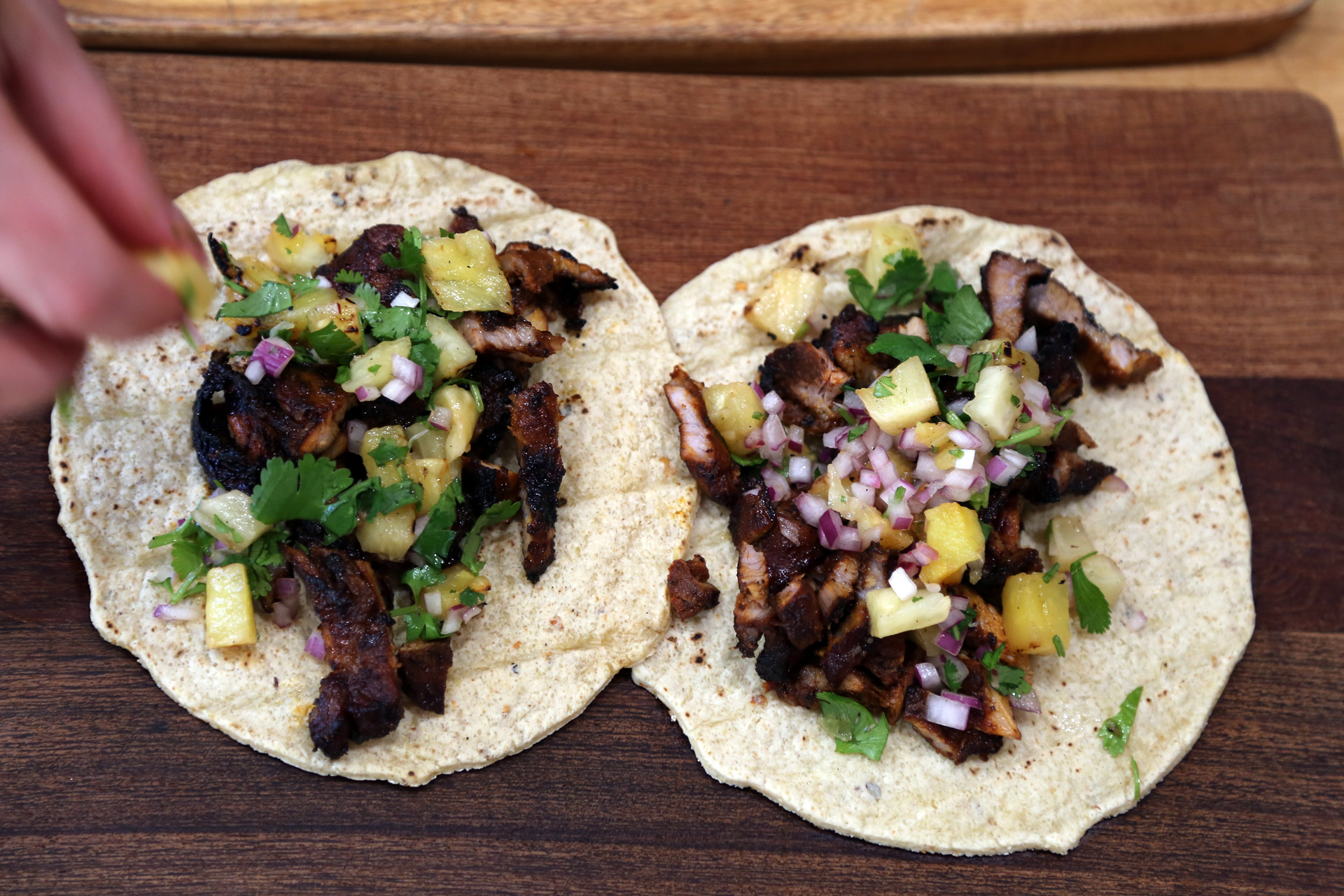 To assemble the tacos, heap some pork al pastor onto a tortilla, top with the pineapple mixture.