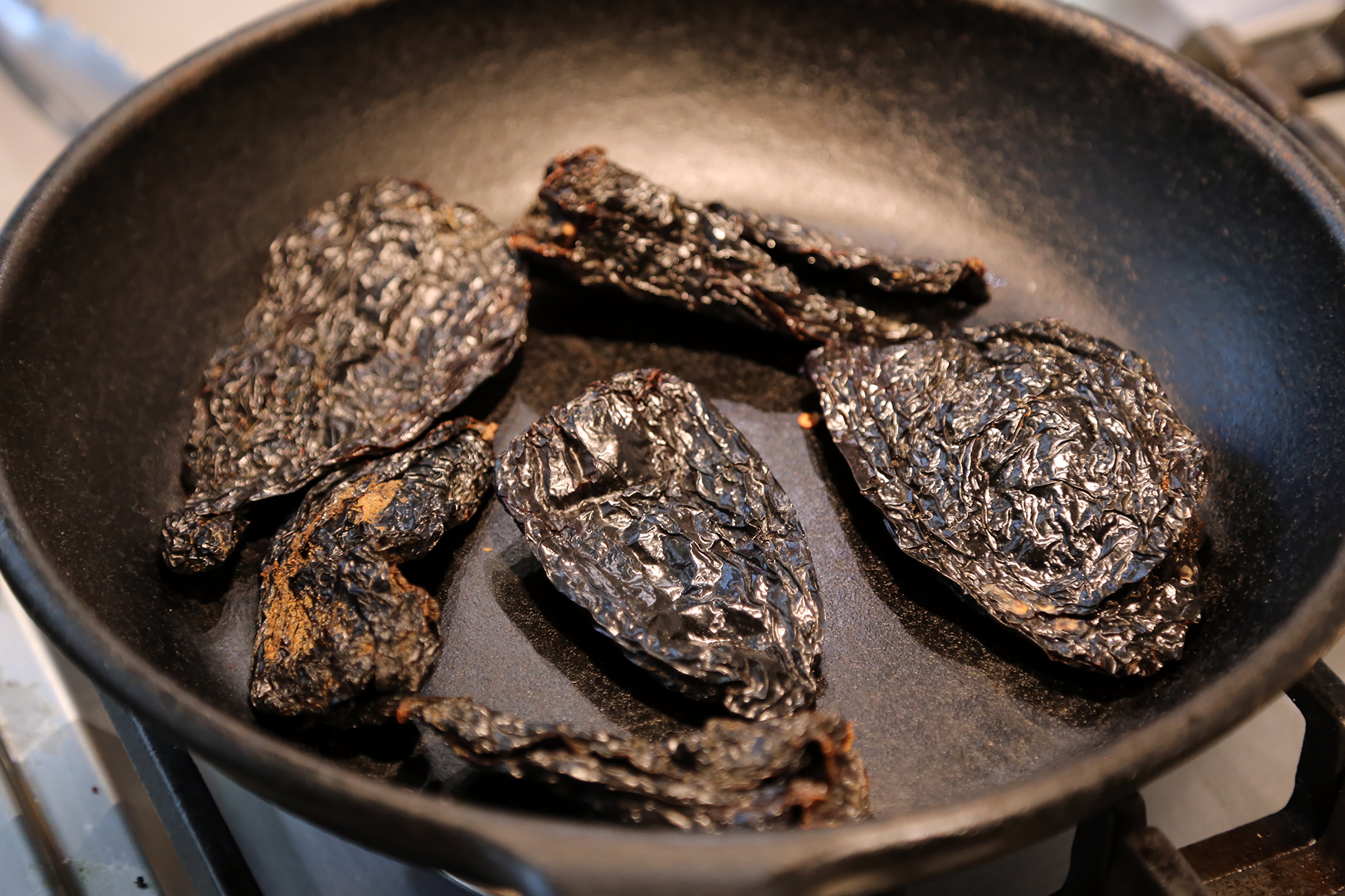 In a large skillet (with a lid) over medium heat, toast the chiles until fragrant and toasted, turning often, about 5 minutes.